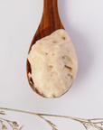 wooden spoon with white cream acne serum in it. 