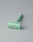 Green hair removal tool with 'J&L Naturals' branding on a gray background