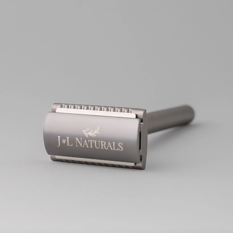 Gray safety razor with 'J&L Naturals' branding on a light gray background